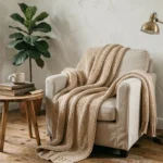 Coin salon douillet avec fauteuil en lin, plaid en laine tressée et table en bois rond dans un intérieur scandinave chaleureux