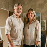 Couple d'artistes dans un atelier de peinture entouré de toiles et de pinceaux