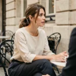 Pauline Sanzey et son compagnon attablés en terrasse parisienne, préservant leur intimité loin des regards